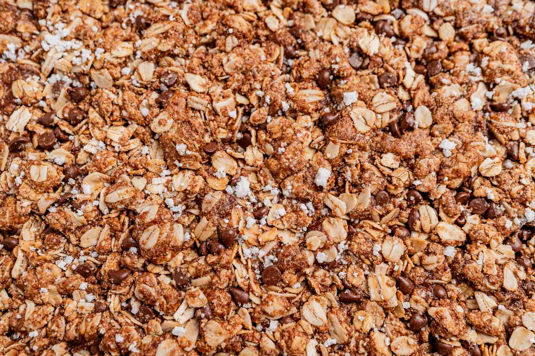 Close-up of chocolate chip cookie granola with oats, rich chocolate chips, and a touch of sprinkled sea salt.