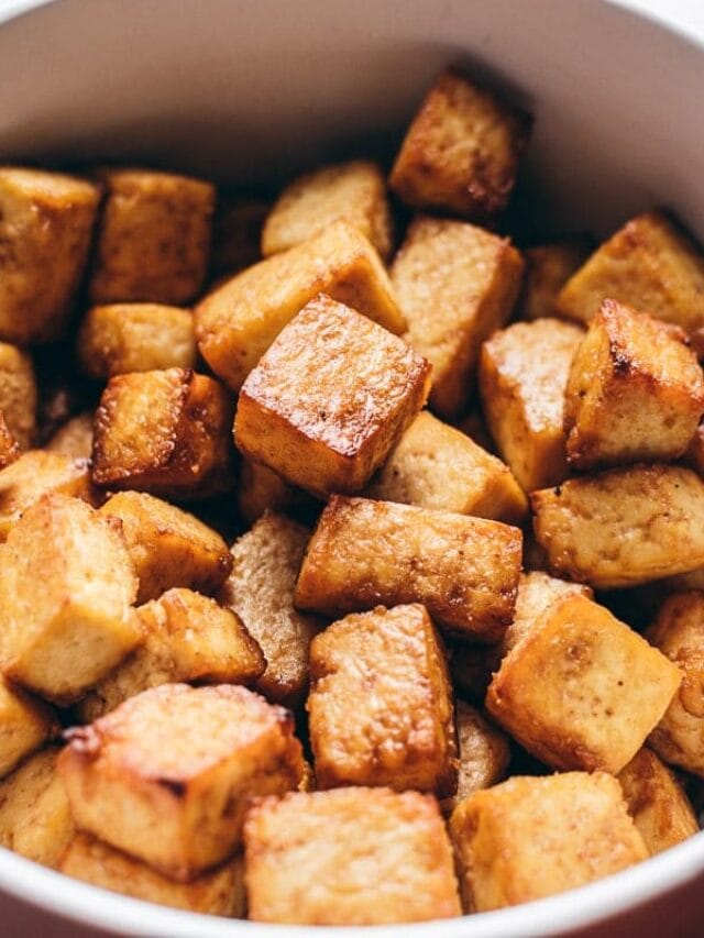 A bowl filled with golden-brown, crispy tofu cubes.