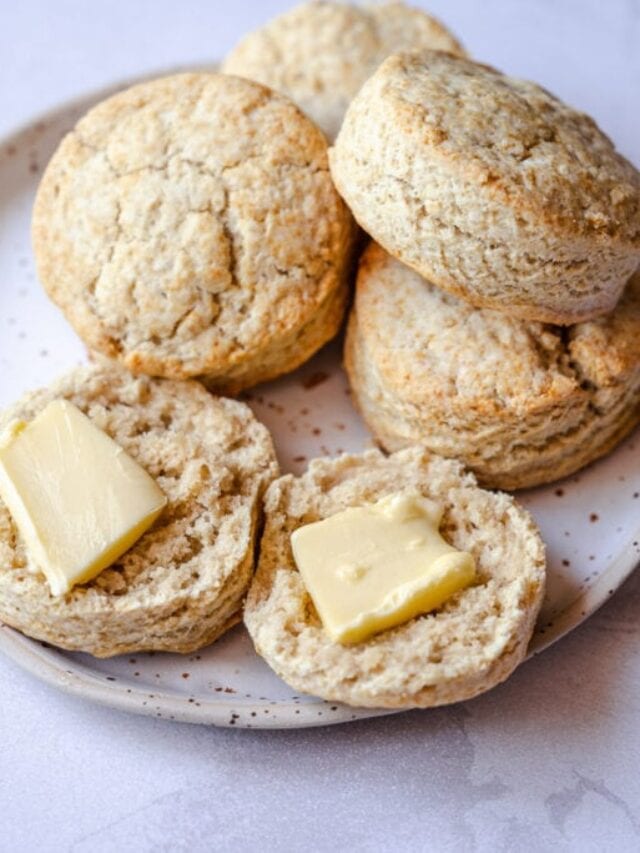 Biscuits stacked on a speckled plate, with one split open showing butter slices.
