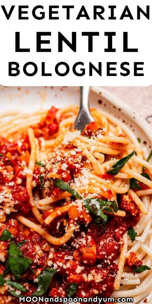 Plate of spaghetti topped with hearty vegetarian bolognese sauce, garnished with grated cheese and fresh herbs.
