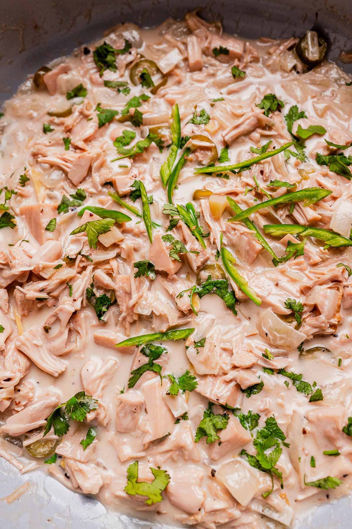 Shredded jackfruit in a creamy ginataang langka sauce, garnished with sliced green chilies and chopped cilantro.