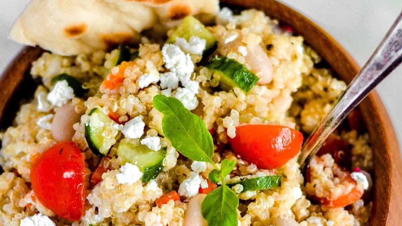 Quinoa salad in a brown bowl, garnished with pita bread.