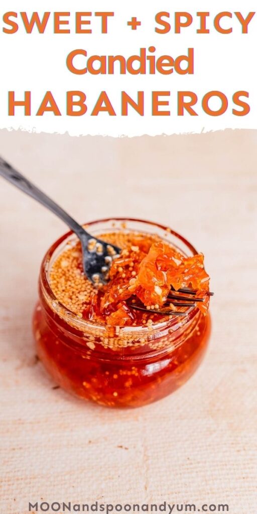 A jar of sweet and spicy candied habaneros with a fork, labeled "Sweet + Spicy Candied Habaneros," from moonandspoonandyum.com. Perfect for those who love the bold flavor of candied habaneros in every bite.
