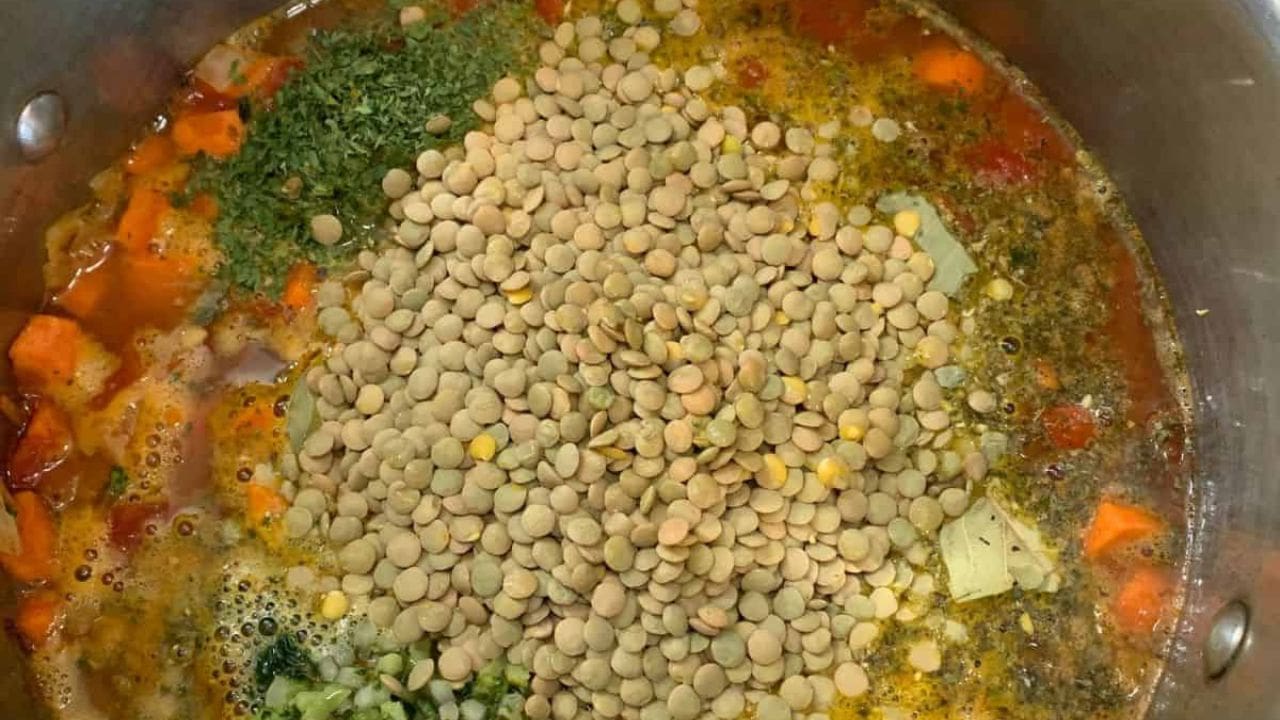 A pot of veggie lentil soup, filled with vegetables and lentils.