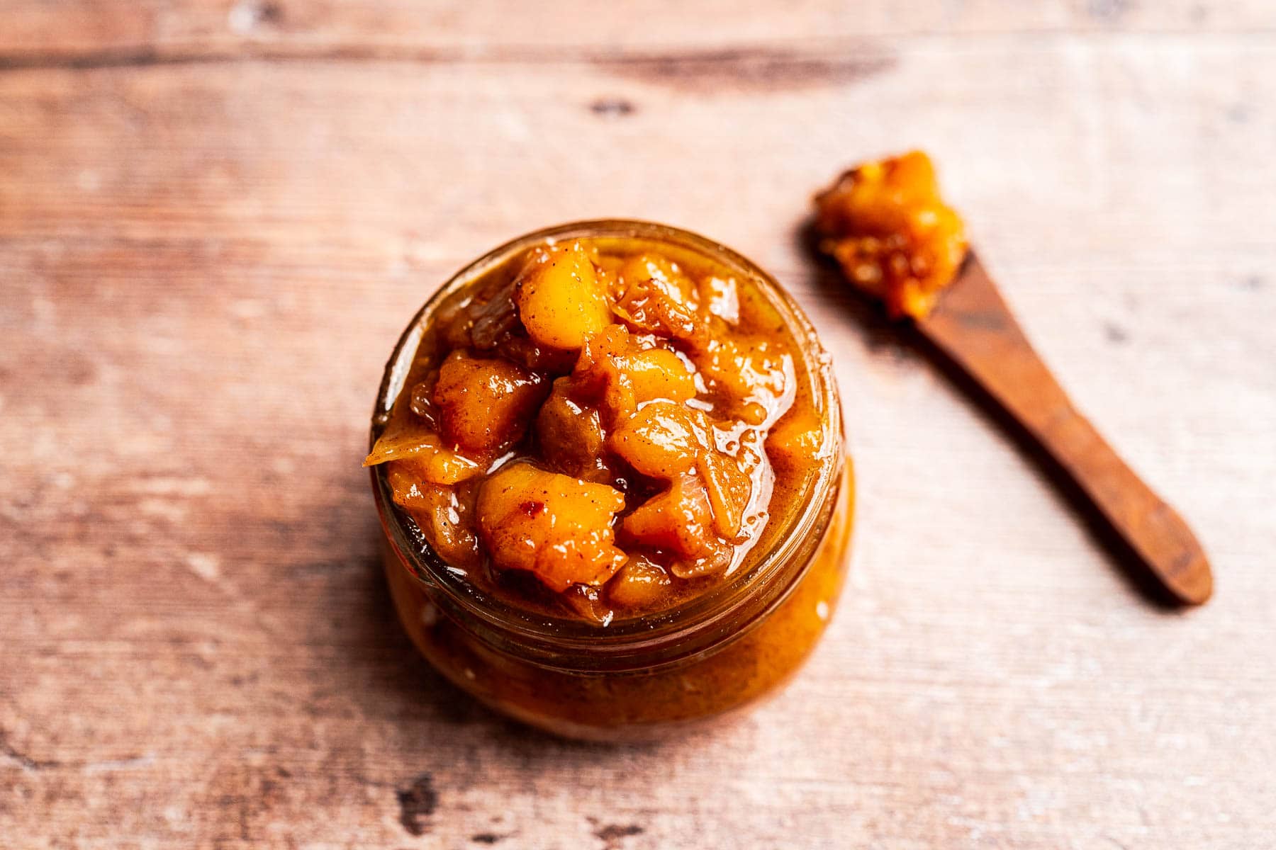 Close-up of sweet and tangy peach chutney in a glass jar.
