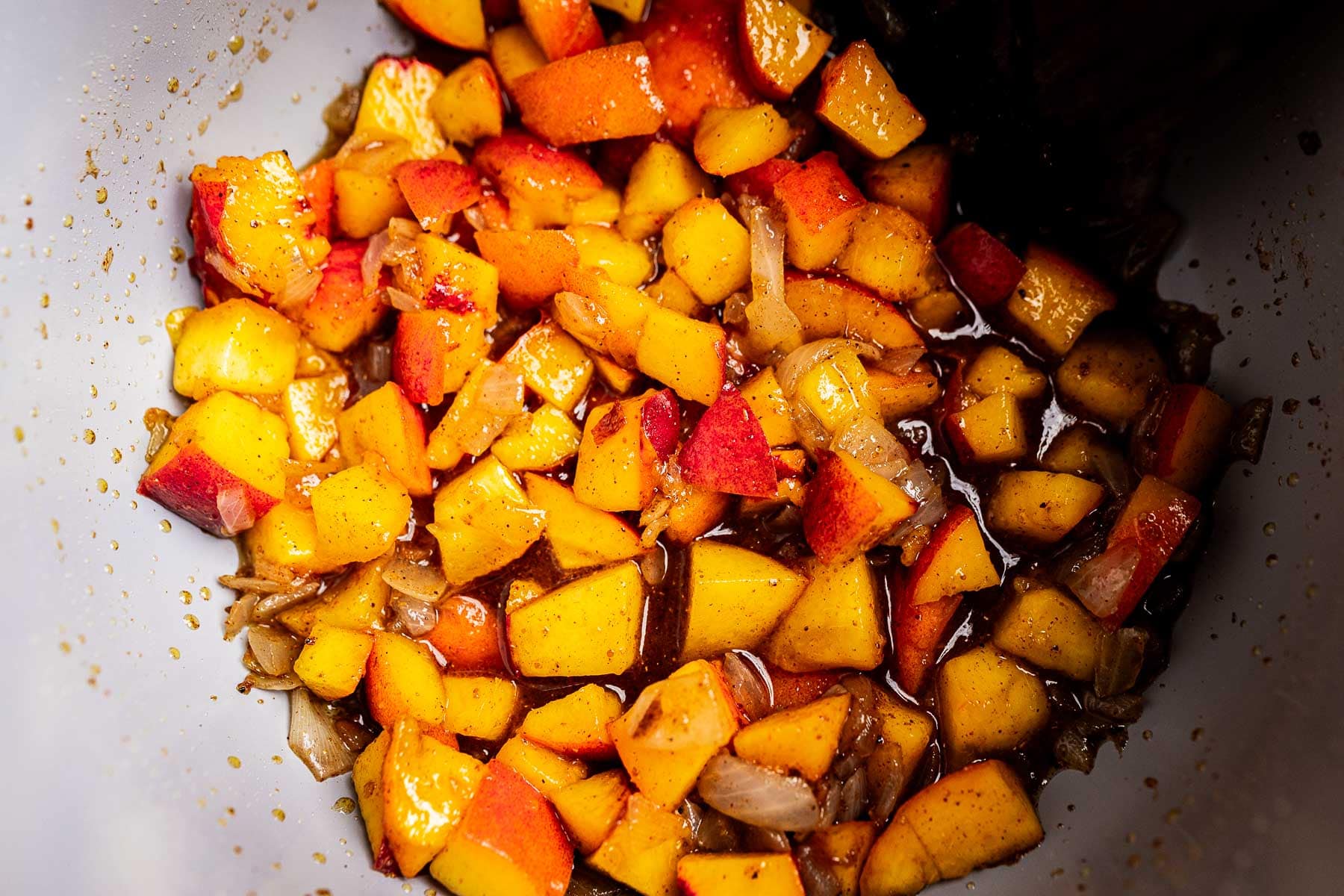 Halfway cooked peach chutney in a pot.