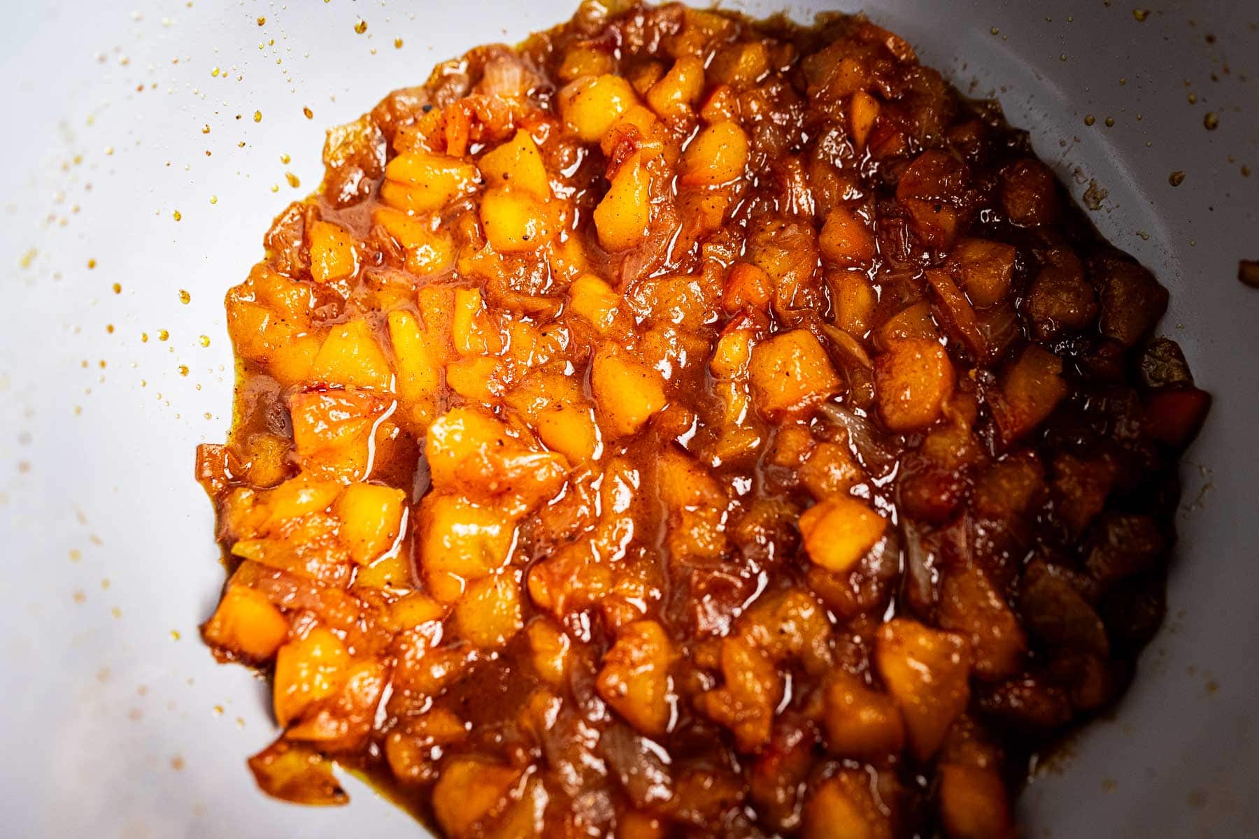 Peach chutney simmering in a pot.