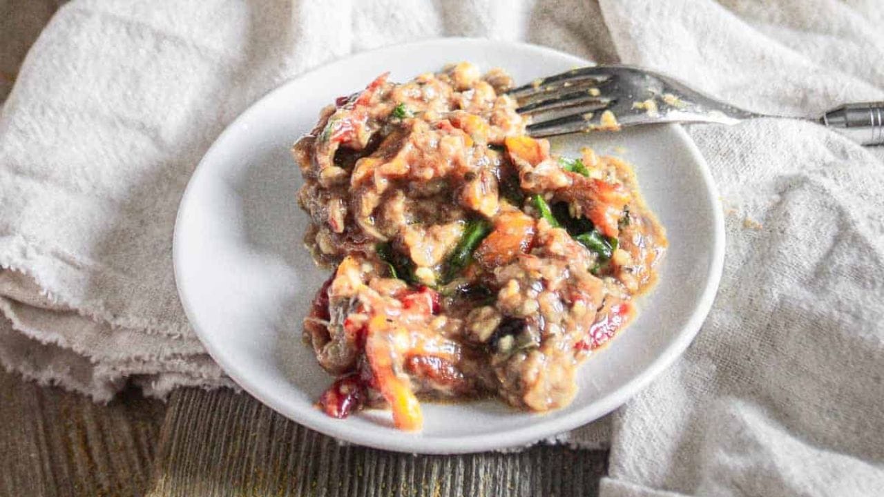 Zaalouk in a white plate with spoon and napkin.