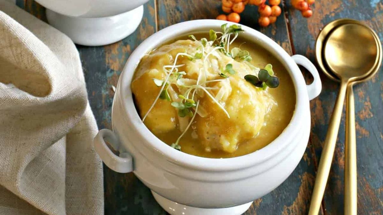 Two bowls of butternut squash soup on a wooden table.