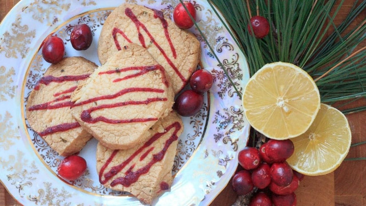 A tray of cookies with rosemary sprigs on it.