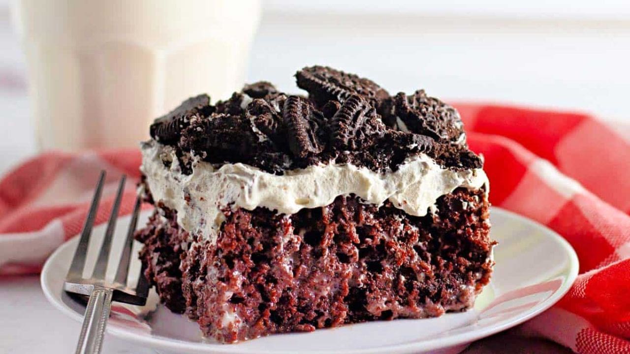 A slice of Oreo poke cake on a white plate.