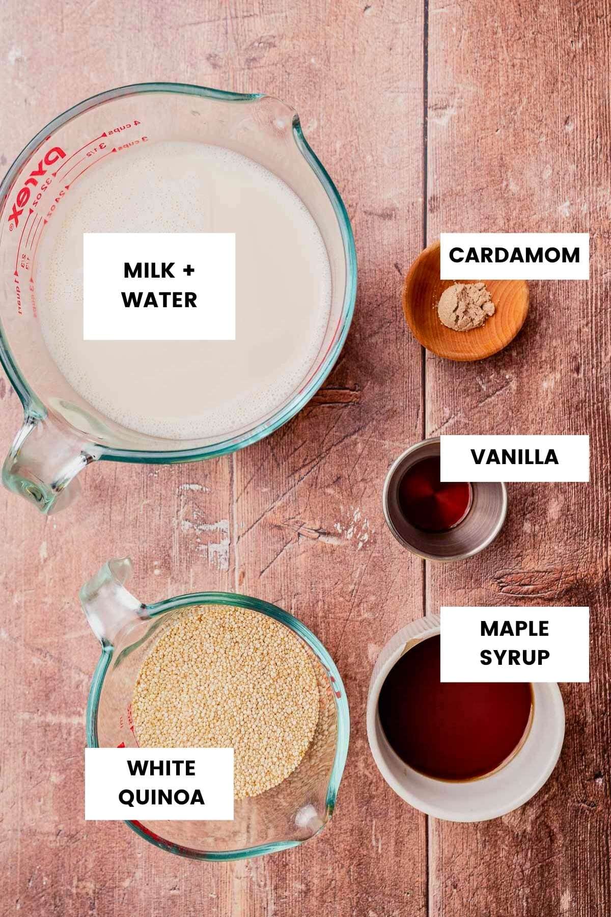 Measured ingredients on a wooden surface: a jug of milk and water, a bowl of cardamom, vanilla, maple syrup, and white quinoa—everything you need for a comforting quinoa breakfast porridge.