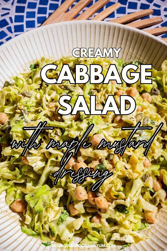 A bowl of creamy cabbage salad with chickpeas, topped with fresh herbs and a maple mustard dressing for a flavorful twist.