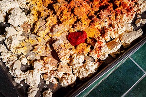 Crumbled tofu shawarma on a baking tray topped with various spices and a dollop of tomato paste.