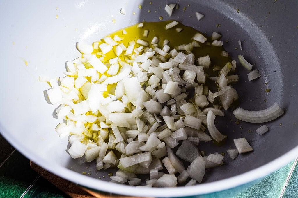 Chopped onions in a pan with olive oil, ready to be cooked—perfect for starting your marry me lasagna soup.