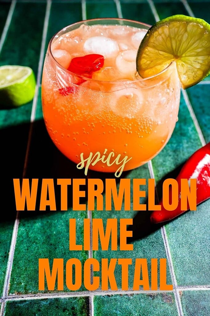 A glass of spicy watermelon mocktail with ice, garnished with a lime slice and red chili, sits on a green tiled surface, surrounded by fresh lime and chili for an extra kick.