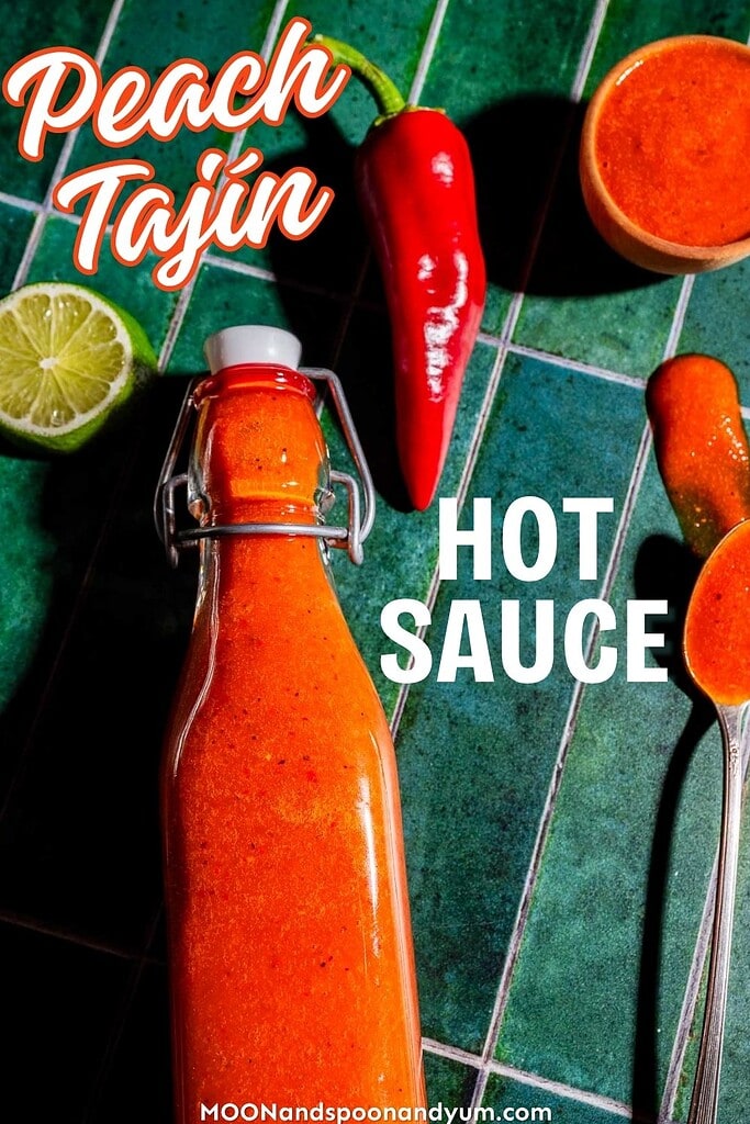 A bottle of orange hot sauce with a red chili, half a lime, a spoonful of sauce, and a full jar on green tiles. Text reads "Peach Tajín Hot Sauce.