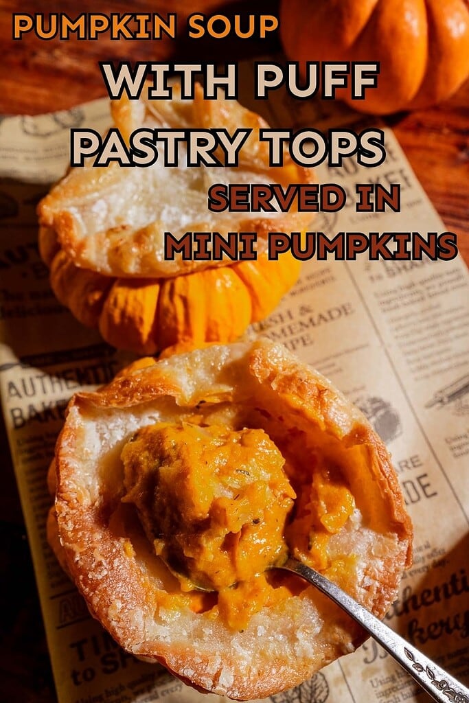 Pumpkin soup puff pastry is artfully presented inside mini pumpkins, each topped with a golden lid of puff pastry. A spoon rests in the foreground on vintage-style paper, completing this charming autumnal scene.
