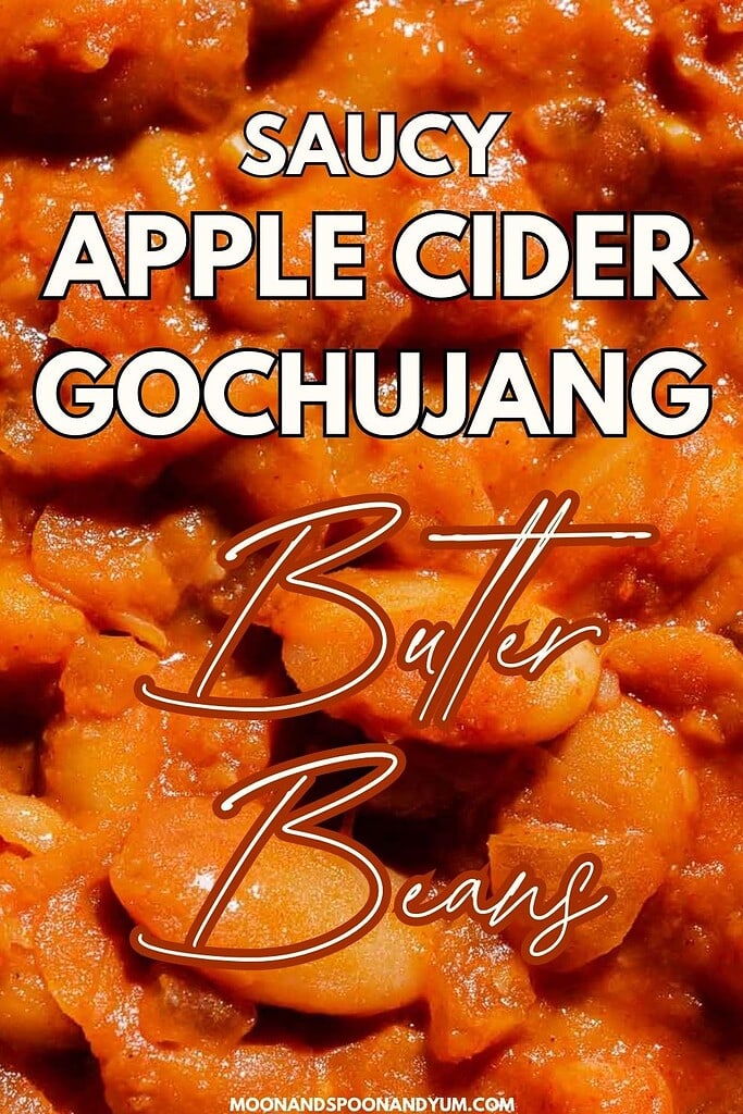 Close-up of saucy apple cider gochujang butter beans, with bold white and orange text overlay describing the dish.