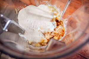 Sugar, vanilla extract, and other baking ingredients in a blender viewed from above, ready to be mixed for a delicious apple creme brulee creation.